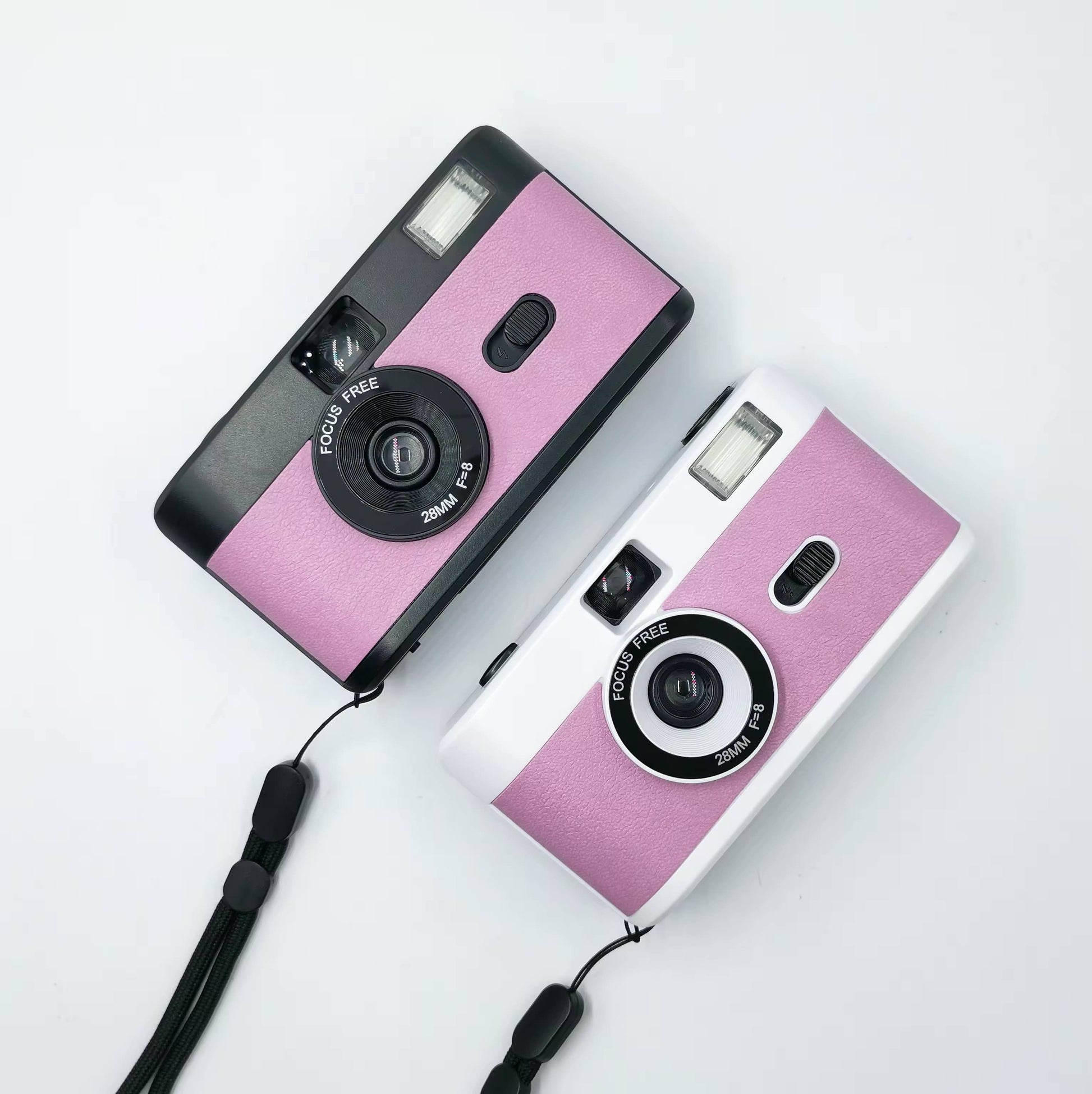 2 vintage looking film cameras a black and pink at the top and a silver and pink at the bottom, aerial view one sits under the other. Wedding accessory for wedding guests. 